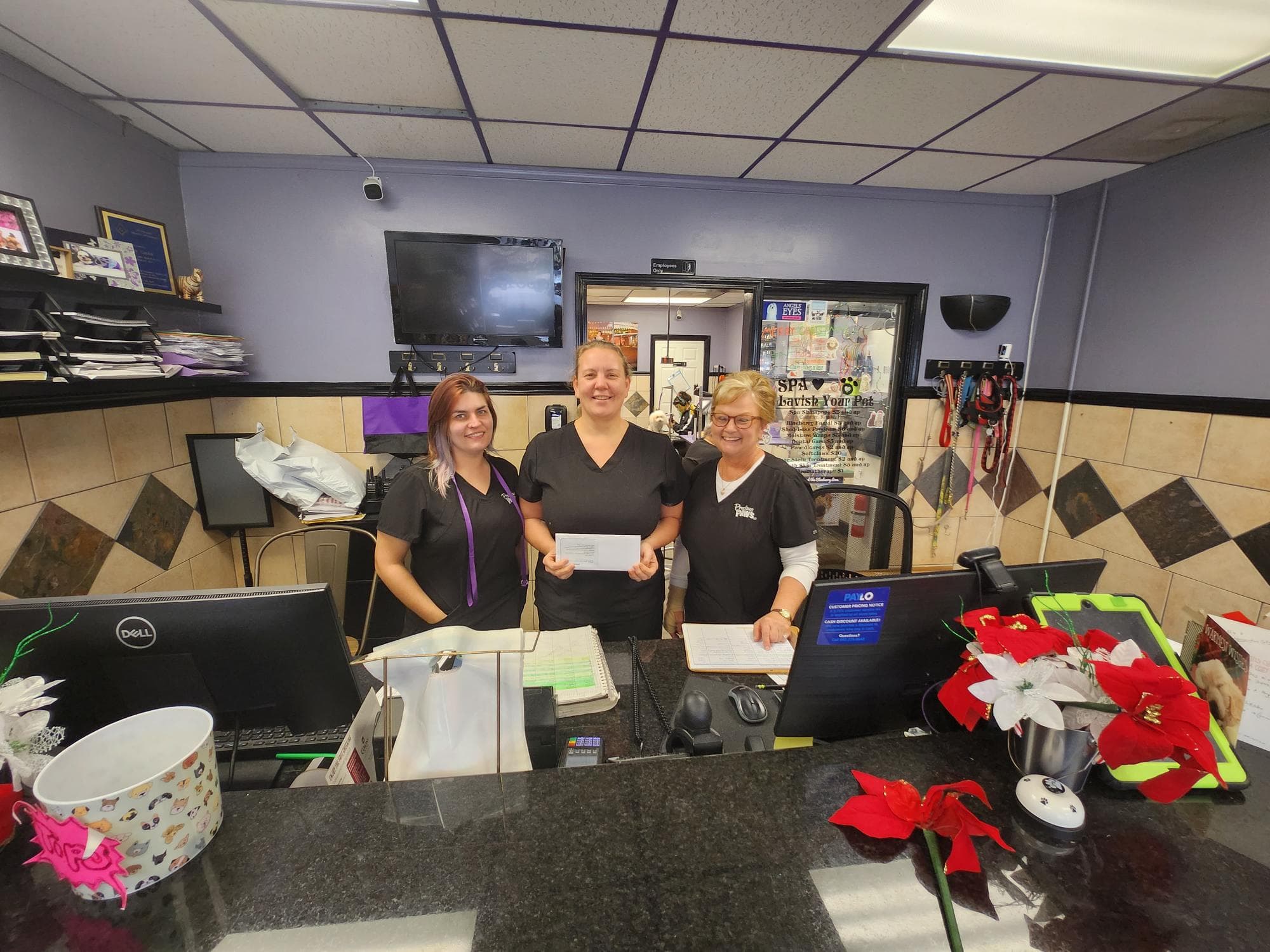 Pet spa staff at reception with rewards envelope, Omega Rewards program partner
