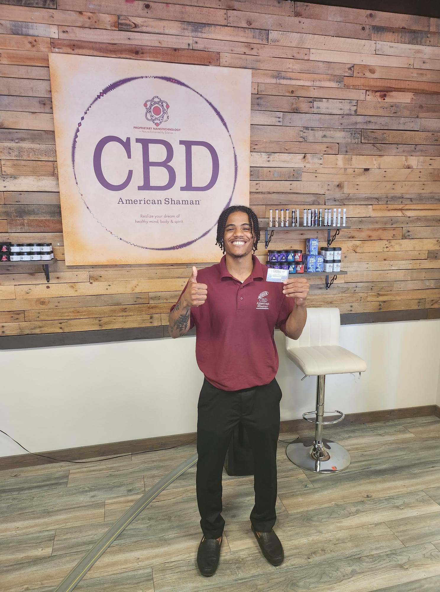 CBD retail merchant giving thumbs up with Croft rewards program card in store